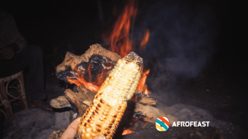 Freshly grilled maize cooking over an open night-market fire